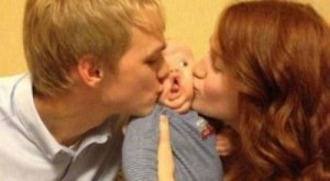 baby kissed by dad and mom between funny