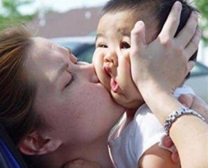 mother kisses baby big mouth